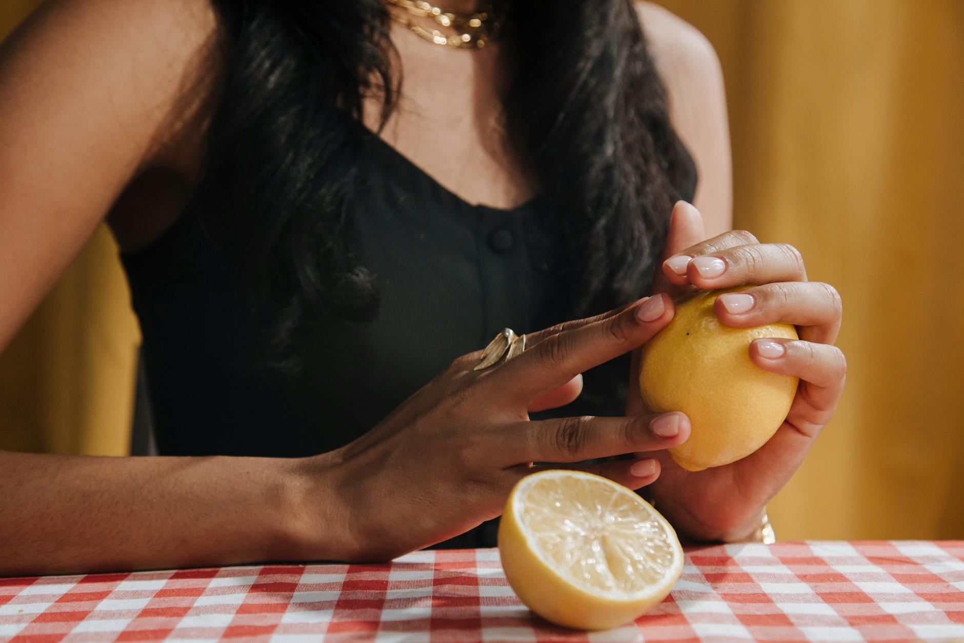 Donna con capelli neri che tiene un limone fresco durante una pausa di consapevolezza
