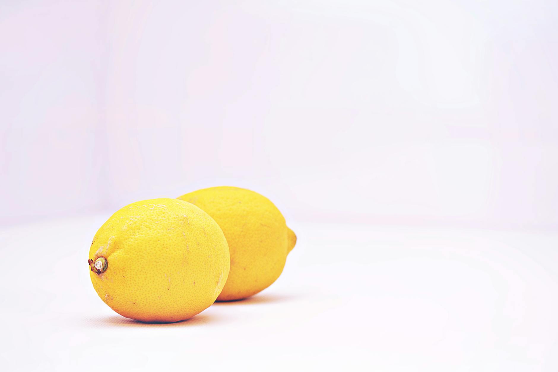 Two vibrant lemons on a white background, representing the fresh, responsive feeling of pleasure during peak cycle days