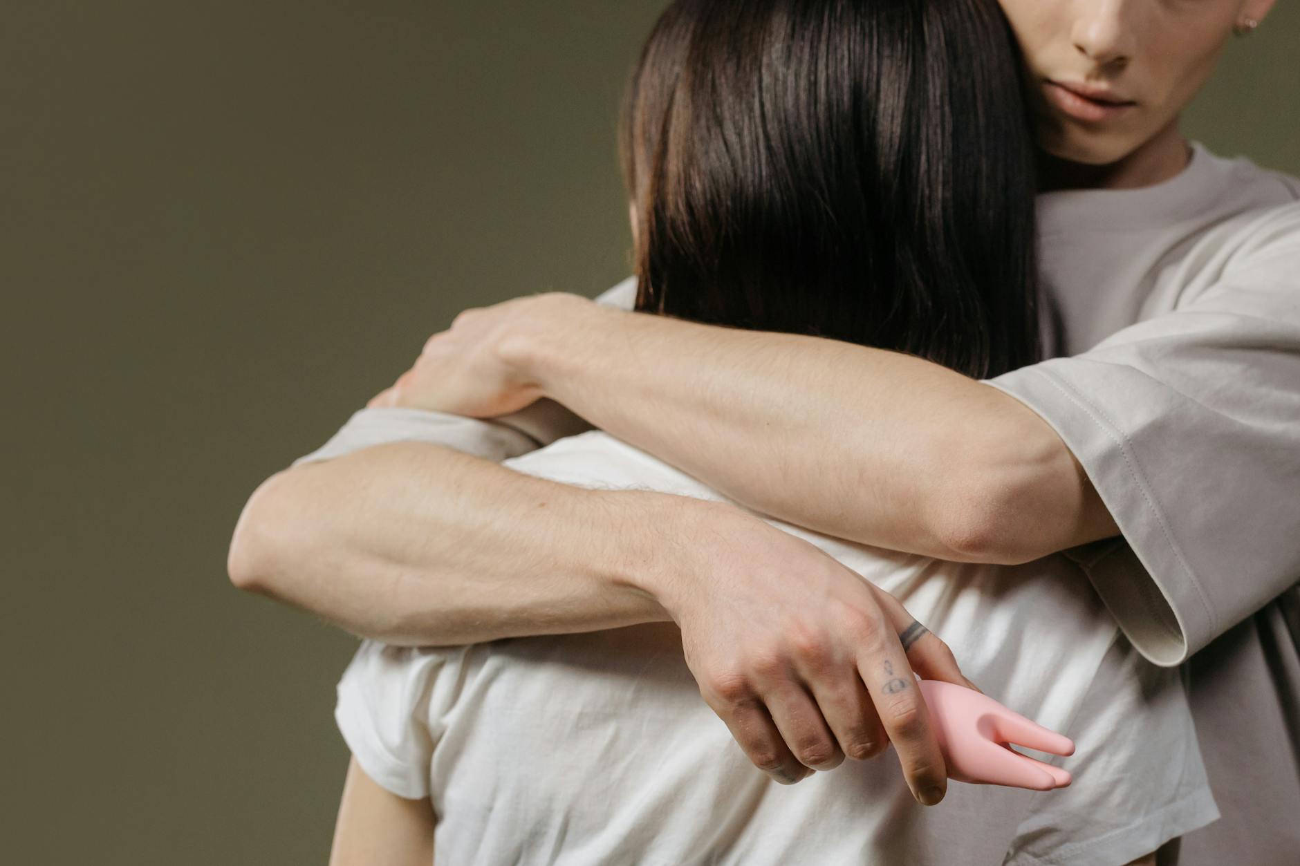 Una mano che tiene un limone su uno sfondo rosa morbido, circondata da altri limoni, simbolo di rinnovamento e scoperta intima dopo la menopausa.
